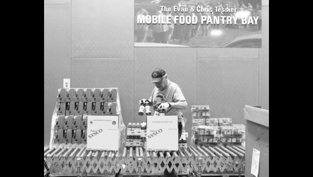 Despite being in an age category that is at higher risk for serious COVID-19 symptoms, longtime Pierre resident Don Zeller has continued to volunteer at the Feeding South Dakota distribution center during the pandemic. Nick Lowrey, South Dakota News Watch