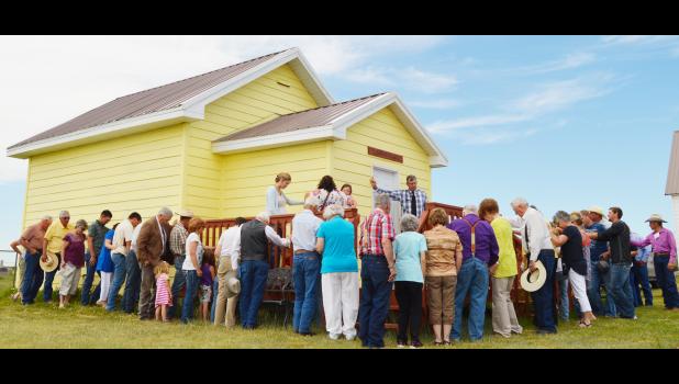 Congregants gather around the Children's Chapel to pray over it during its dedication. Many hands went into refurbishing the structure.