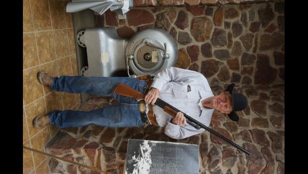 Jim Holloway ... reenacting the summer of 1970 guarding the safe. The safe in the background is the actual safe Jim spent the summer watching over. Courtesy photo