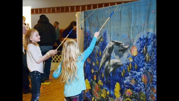 Gone Fishing ... These girls have cast their poles and are waiting patiently for a bite on the line, at Family Fun Festival held Sunday, February 11, 2018. Notice all the sea life swimming by? Looks like a few great fish stories!