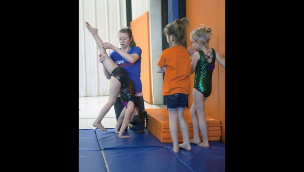 Abby provides step by step instruction to the young gymnasts.