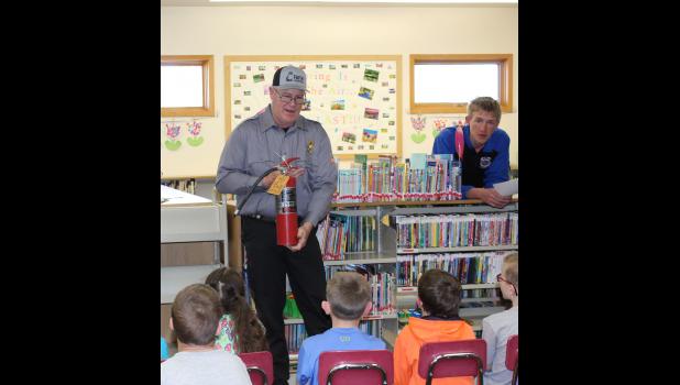 Photo courtesy Brooklyn Hanson Firefighters Lenae Haines and Jade Mortenson with Chief Justin Haines explaining to students how firefighters will be dressed when entering a burning structure.
