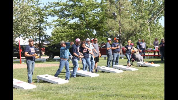 Two opposing rows of corn hole players played round after round with each other, working against the wind to hit their mark.