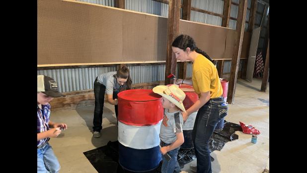 Painting ... the barrels to be used during the rodeo performances. Photo courtesy Gnene Fordyce