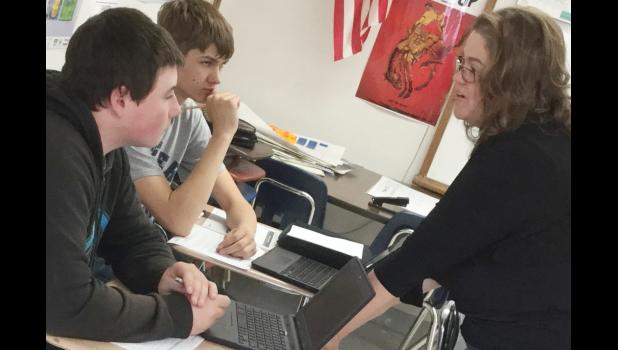 Jacqueline Myers offers friendly instruction to Dalton Madsen and Nate Ludovissie during English I.
