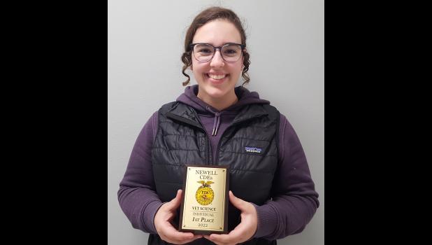 Mesa Krautschun pictured with her 1st Place Individual in Veterinary Science plaque.