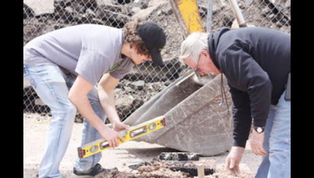 Shay Huether and Bill Tines prepare the basketball court site.