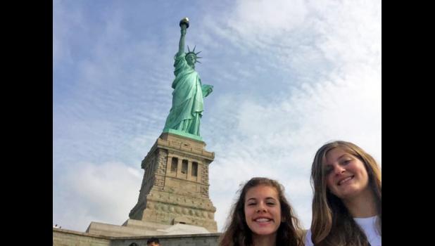 Lilli Moore and Emily Jacobs pose beside New York City’s Statue of Liberty.