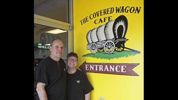 Owners of the Covered Wagon Cafe Russ and Missy Wilbur pose in front of the freshly painted cafe entrance.