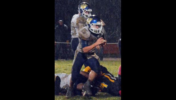 Wall Eagle Carter Elshere (#15) with the football and Camden Sawvell (#28) in the back ground at the rainy Oct. 22 football game in New Underwood.