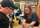 Pharmacist Cindy Dinger checks out tourist Will Lovitt after giving him advice on treating a mysterious rash he developed while visiting the Black Hills of South Dakota. Courtesy Arielle Zionts/KFF Health News