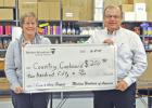 Don Haynes presenting a donation to Carol Hoffman for the Country Cupboard Food Pantry.
