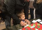 Tyrel Eisenbraun showing his son Landon how to sign up for the door pizes. Courtesy photo 2018 Pancake supper.