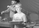 Jaxon Erikson helps show off the auction items.