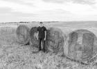 Adrik Schoon volunteered to paint “JC4H” on hay bales along Highway 83 south of Murdo. Photo by Lealand Schoon